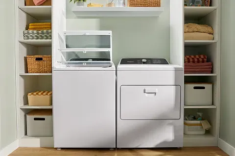 White Whirlpool WTW5025SW top-load washer and dryer installed in a laundry closet.